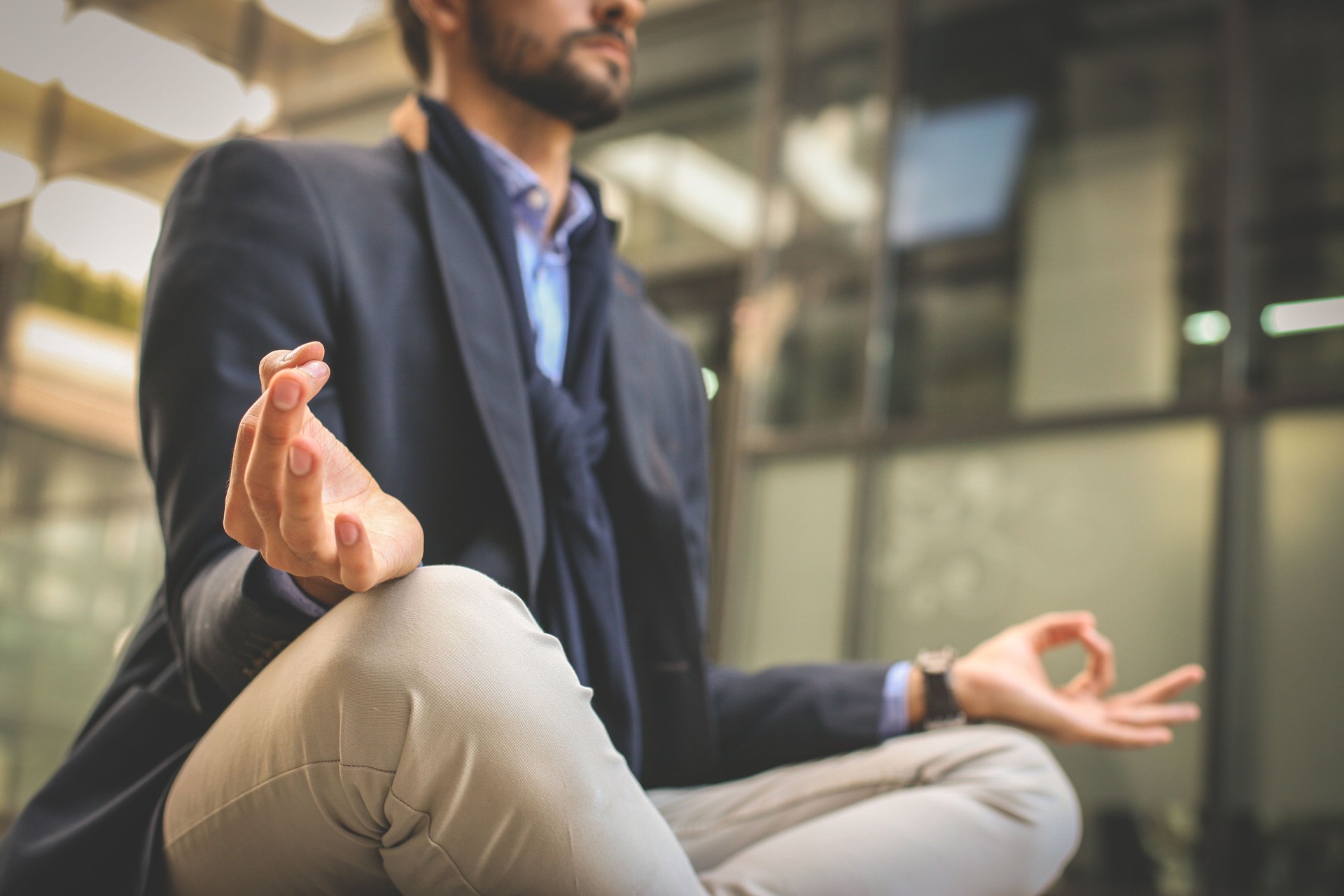 Businessman practicing yoga on the street.