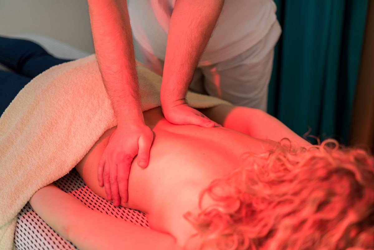 Female patient getting a relaxing massage, infra red healing and bio energy healing.